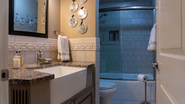 full bathroom with vanity, toilet, enclosed tub / shower combo, and tile patterned flooring
