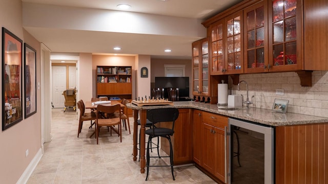 indoor wet bar featuring wine cooler, backsplash, recessed lighting, and baseboards
