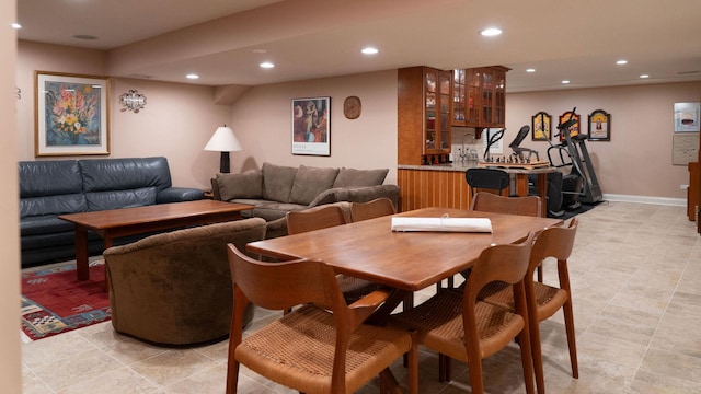 dining room featuring recessed lighting, light tile patterned floors, bar area, and baseboards