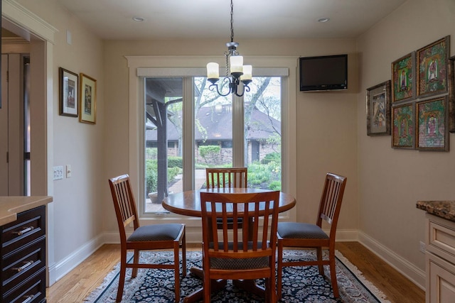 dining room featuring light wood-style floors, a chandelier, baseboards, and recessed lighting