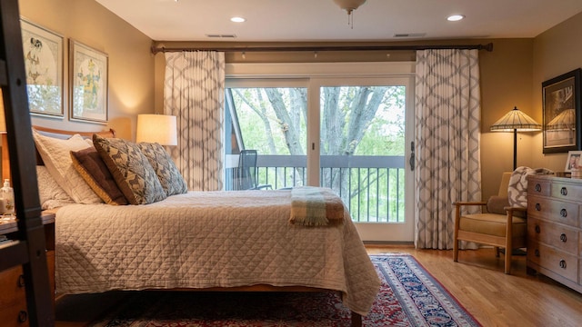 bedroom with access to exterior, multiple windows, wood finished floors, and recessed lighting
