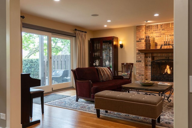 living room featuring recessed lighting, wood finished floors, and a fireplace