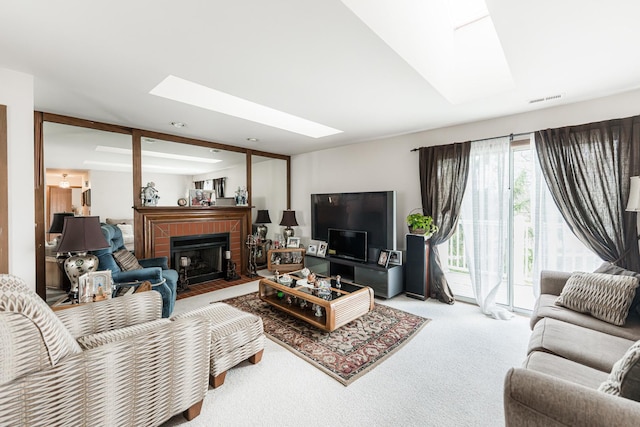 living area with a skylight, a brick fireplace, visible vents, and carpet