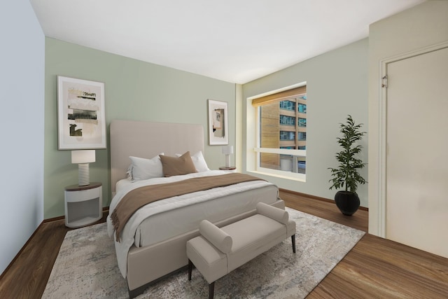 bedroom with wood finished floors and baseboards
