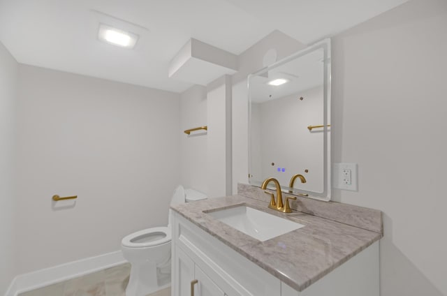 half bath featuring toilet, vanity, and baseboards