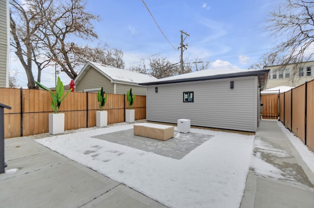 rear view of property with an outbuilding, a fenced backyard, and a patio