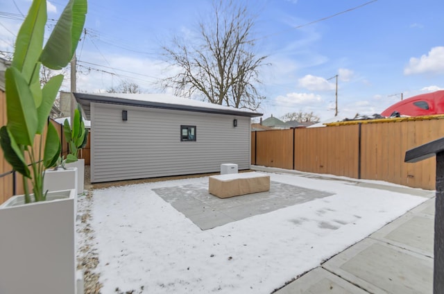 rear view of house with a fenced backyard and an outdoor structure