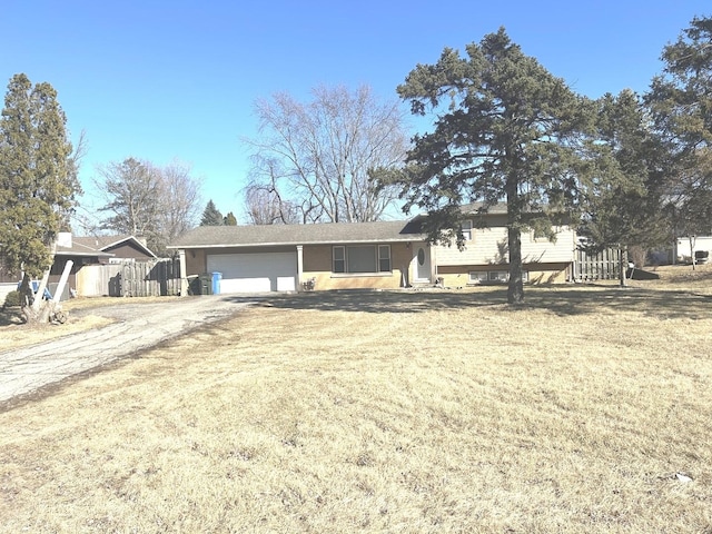 ranch-style house featuring driveway, a garage, and a front lawn