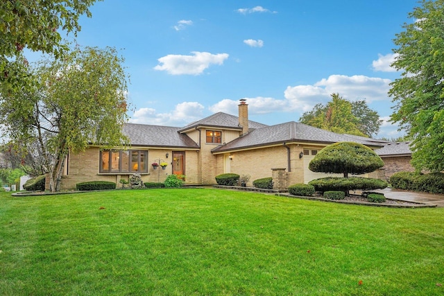 view of front of house with a shingled roof, a front lawn, a chimney, and a garage