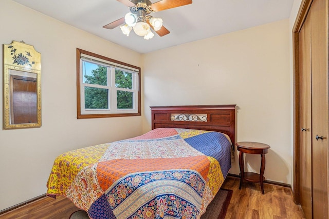 bedroom featuring baseboards, wood finished floors, a closet, and ceiling fan