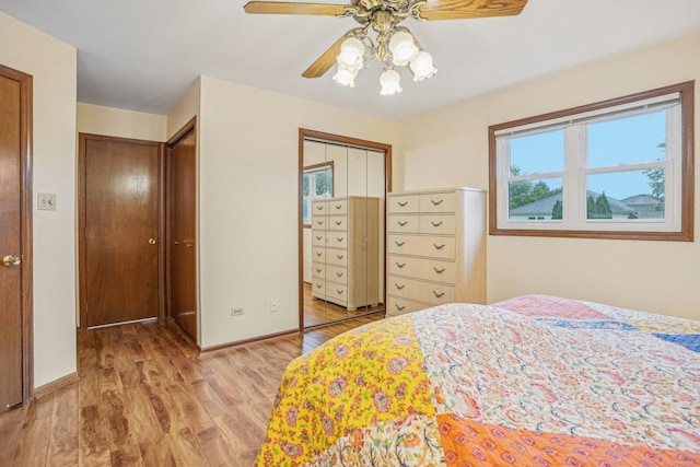 bedroom featuring light wood-style floors, a closet, baseboards, and ceiling fan