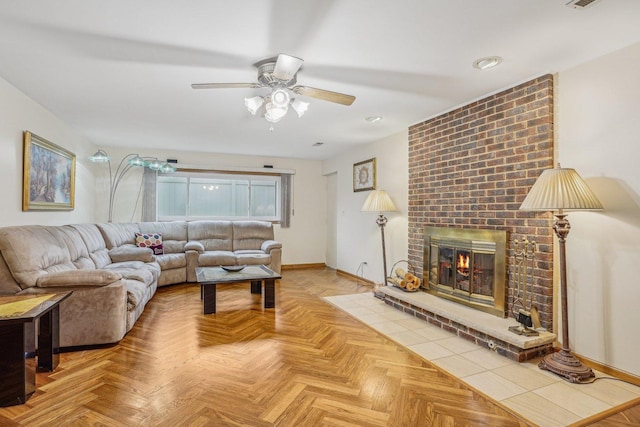 living room with a fireplace, a ceiling fan, and baseboards