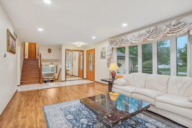 living room with recessed lighting, stairway, baseboards, and wood finished floors