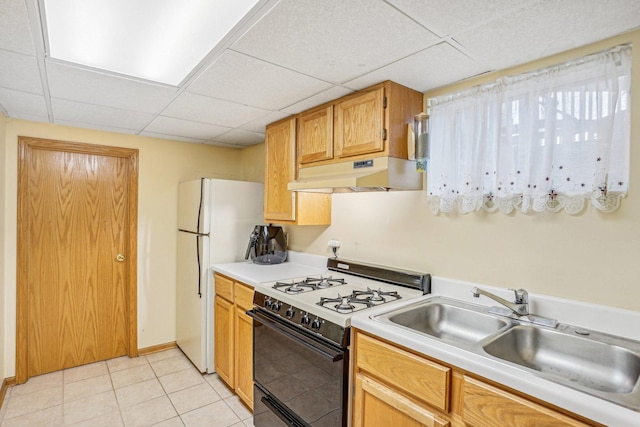 kitchen featuring a paneled ceiling, a sink, gas stove, light countertops, and under cabinet range hood