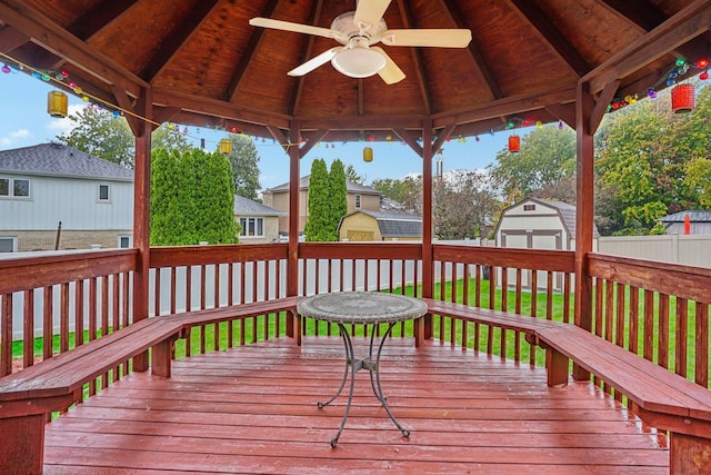 deck featuring an outdoor structure, a gazebo, a shed, and ceiling fan
