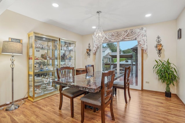 dining area featuring baseboards, a notable chandelier, light wood finished floors, and recessed lighting