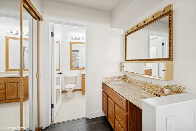 full bath with toilet, baseboards, tile patterned floors, and vanity