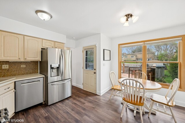 kitchen with light countertops, baseboards, stainless steel appliances, and dark wood finished floors