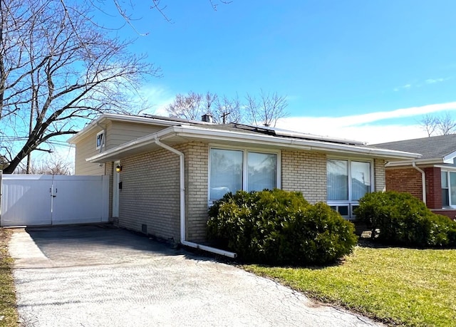 14301 Dorchester Ave, Dolton, IL 60419 - view of side of home with brick siding, a gate, and solar panels