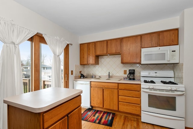 8509 Hemlock St, Orland Park, IL 60462 - kitchen with tasteful backsplash, a sink, white appliances, light wood-style floors, and brown cabinetry