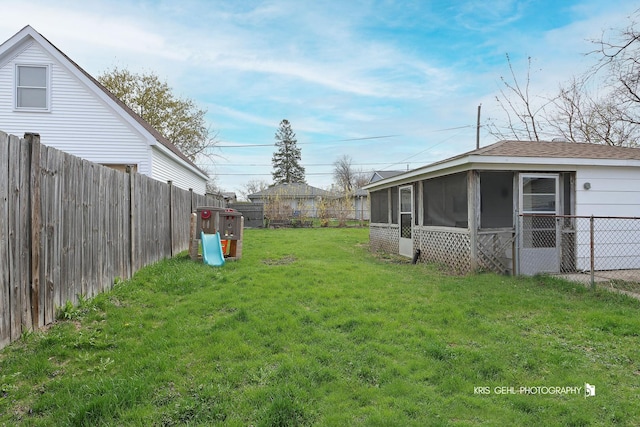 view of yard featuring a fenced backyard and a sunroom
