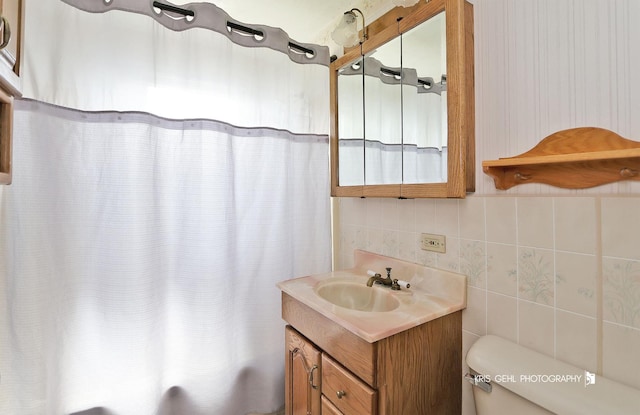 bathroom featuring toilet, tile walls, backsplash, shower / tub combo with curtain, and vanity