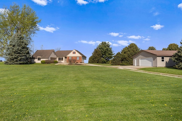 view of front of home featuring a front lawn, an outbuilding, and driveway