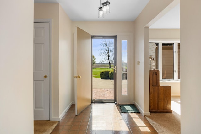 doorway featuring baseboards and tile patterned flooring