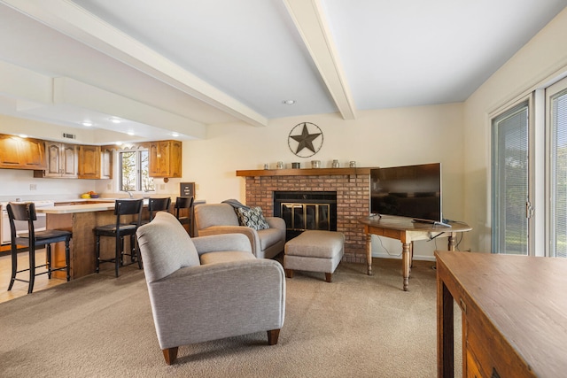 living area featuring visible vents, a brick fireplace, light carpet, and beamed ceiling