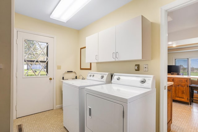 clothes washing area featuring cabinet space, separate washer and dryer, visible vents, and a healthy amount of sunlight