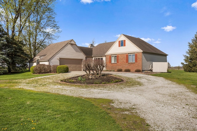 traditional-style house featuring brick siding, a garage, a front yard, and curved driveway