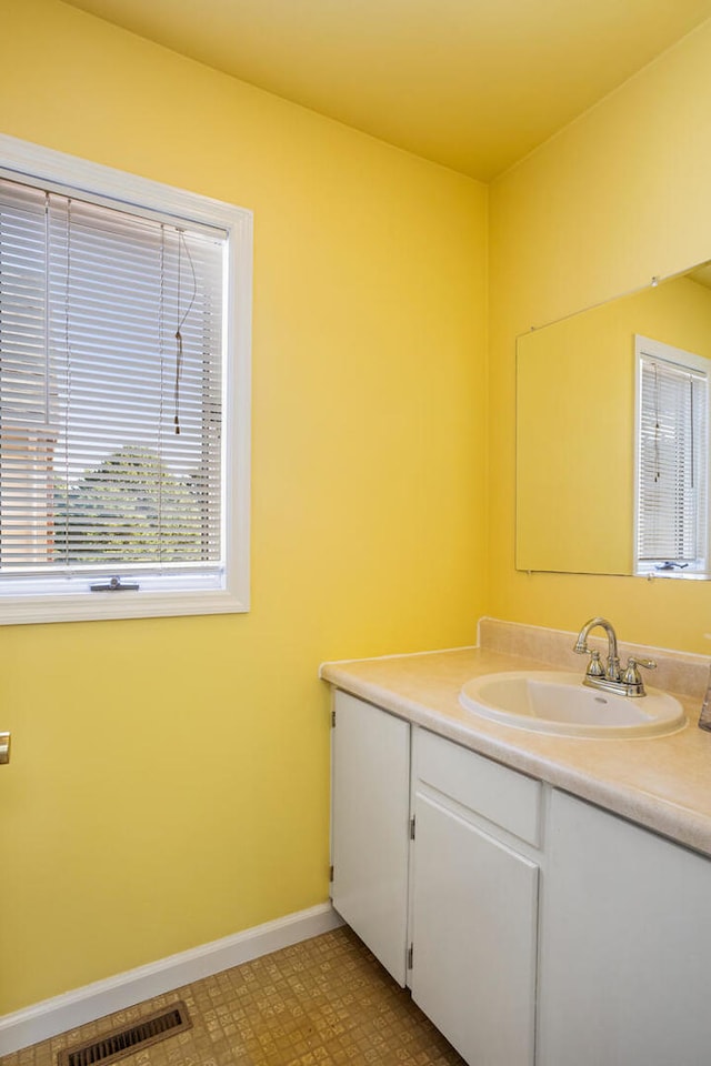 bathroom with visible vents, baseboards, and vanity