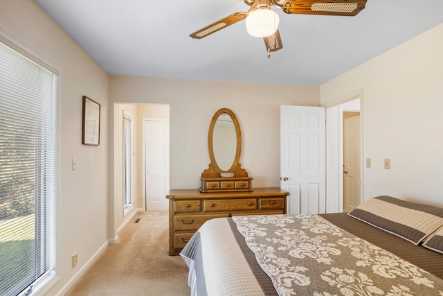 bedroom featuring baseboards, light carpet, and a ceiling fan
