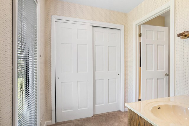 bathroom featuring vanity and wallpapered walls