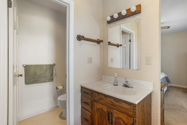 bathroom with vanity, baseboards, and toilet