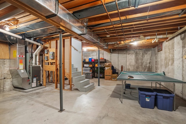 unfinished basement featuring heating unit and stairway