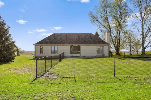 rear view of house featuring a fenced backyard, a chimney, and a yard
