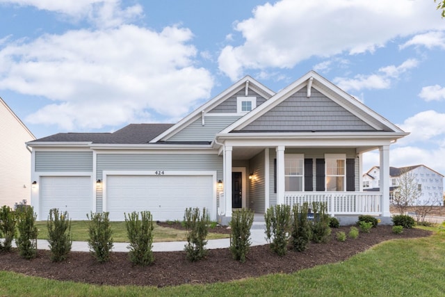 craftsman-style house with an attached garage, covered porch, and driveway