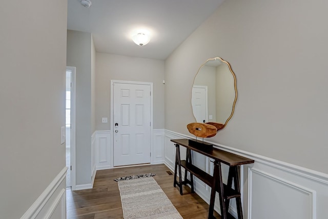 doorway featuring wainscoting and dark wood finished floors