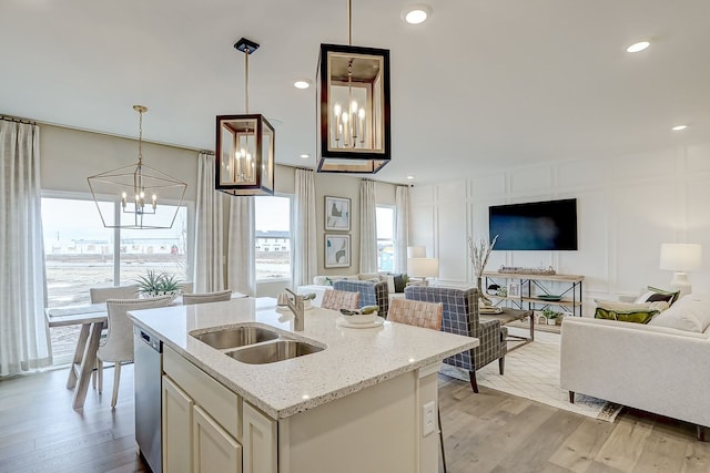 kitchen featuring open floor plan, a decorative wall, an inviting chandelier, and a sink