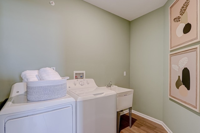 laundry area with independent washer and dryer, light wood-style floors, and baseboards