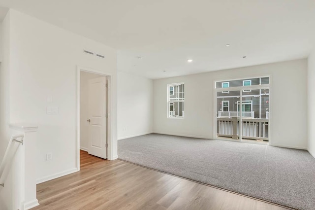 empty room with wood finished floors, baseboards, and recessed lighting