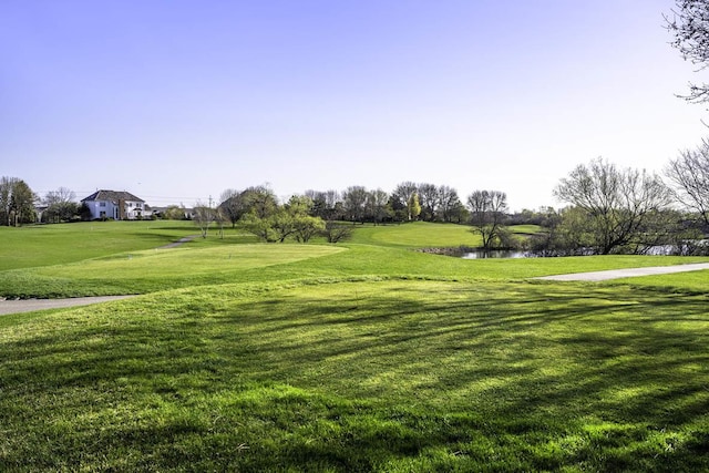 view of home's community featuring a water view, golf course view, and a lawn