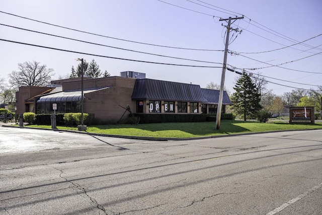 view of front of house featuring a front yard and metal roof