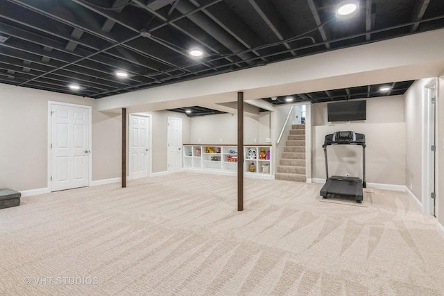 finished basement featuring carpet flooring, baseboards, and stairway