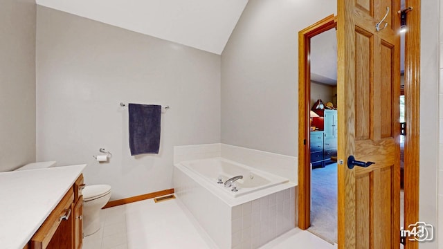 bathroom with a garden tub, toilet, vanity, baseboards, and lofted ceiling