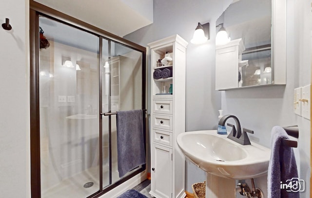 full bath with a sink and a shower stall