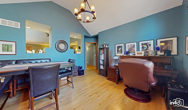 office area with high vaulted ceiling, a notable chandelier, wood finished floors, and visible vents