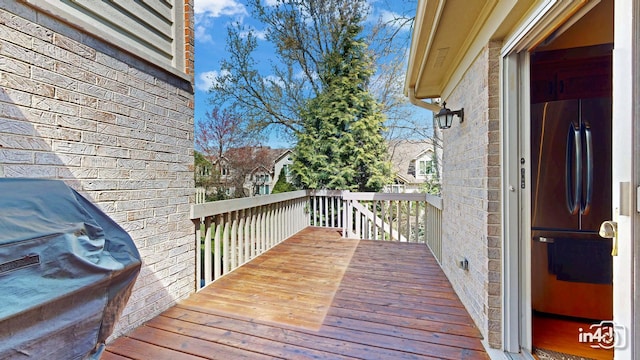 wooden deck featuring a grill