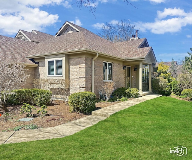 exterior space with a lawn, a chimney, and roof with shingles